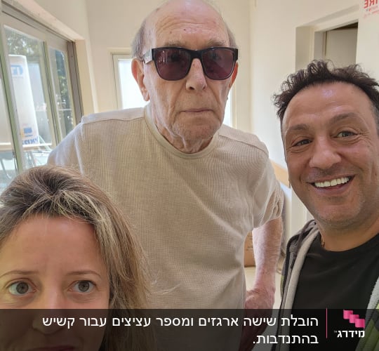 שלושה אנשים מחייכים בתוך חדר מואר